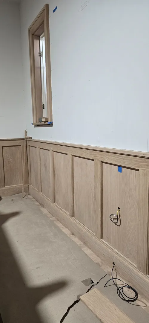 White oak stair wainscot and narrow window trim nearing completion.