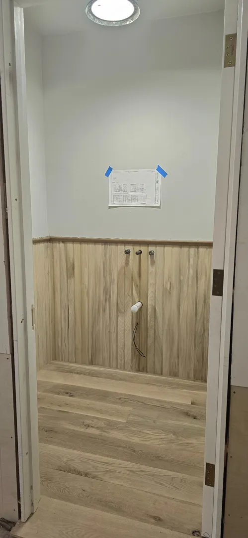 White oak wainscot and paneled stair hall during finish work.