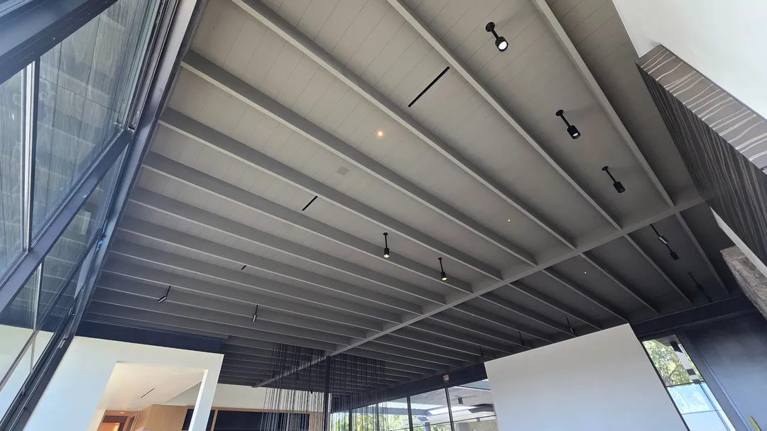 Expansive painted beam-and-board coffered ceiling with integrated lighting at Las Lomas.