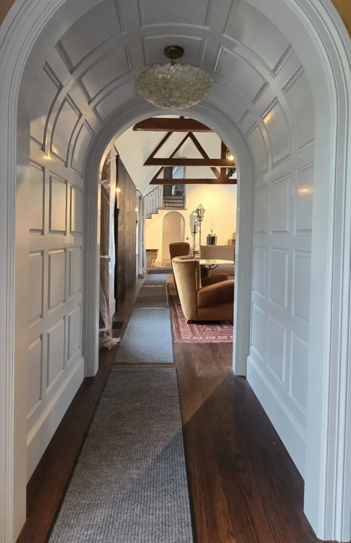 Completed white paneled arched passage leading into the living room.
