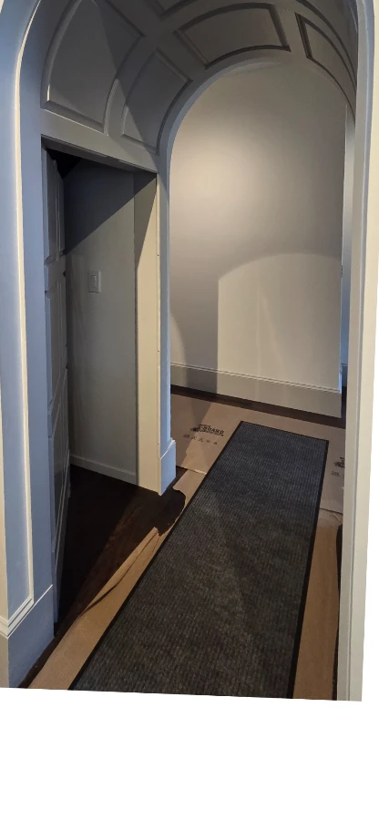 Curved paneled passage with its concealed arched door opened.