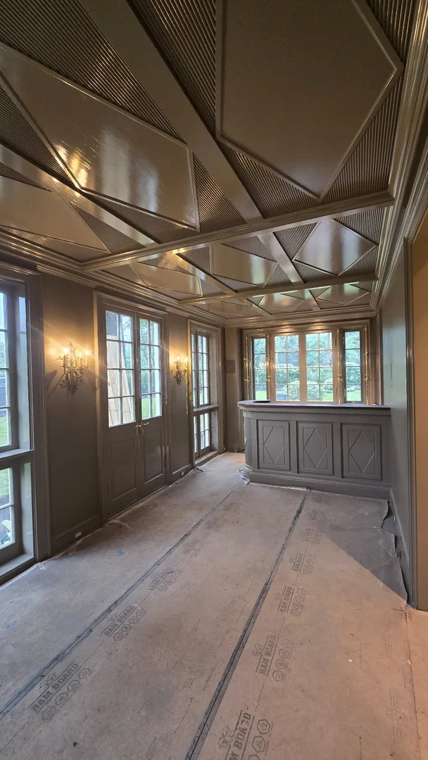 Dark geometric coffered ceiling and custom bar millwork at the Niles project.