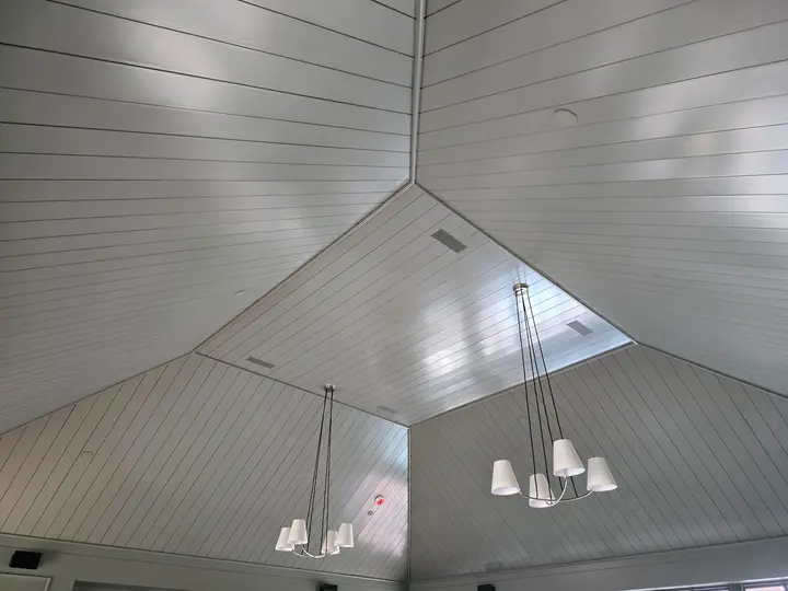 Painted V-groove cathedral ceiling with precise intersecting trim and integrated lighting at Stoneridge.