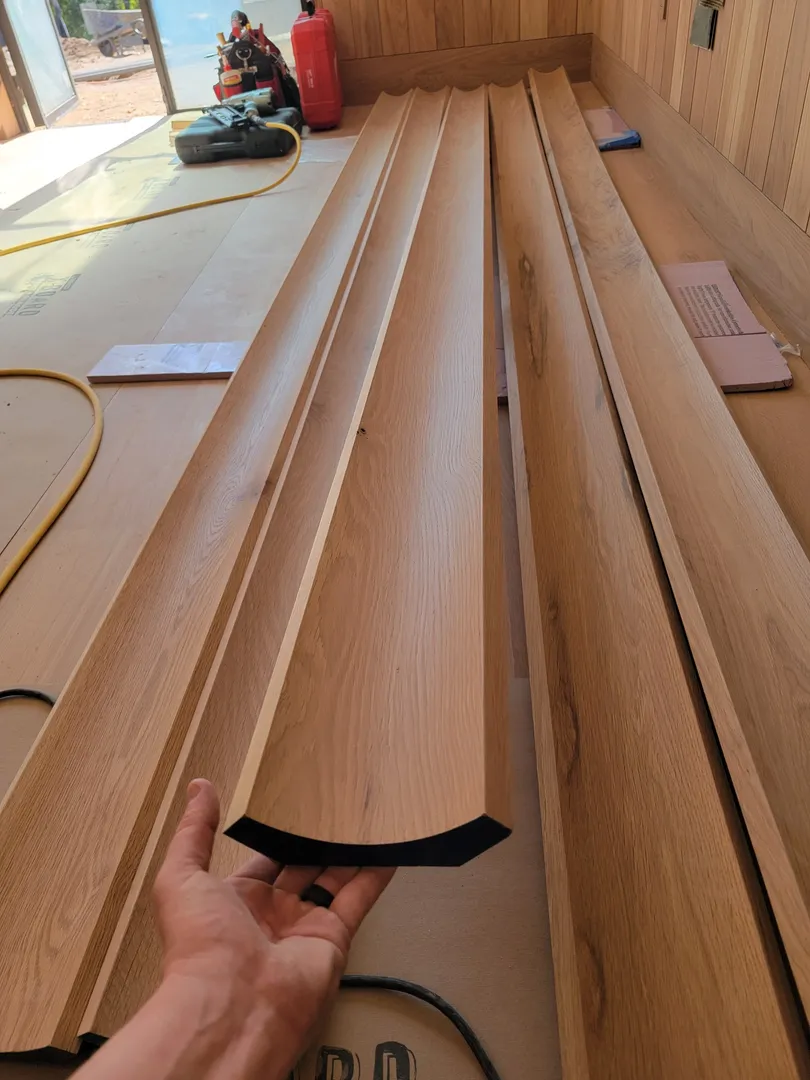 Curved oak millwork components laid out during fabrication.